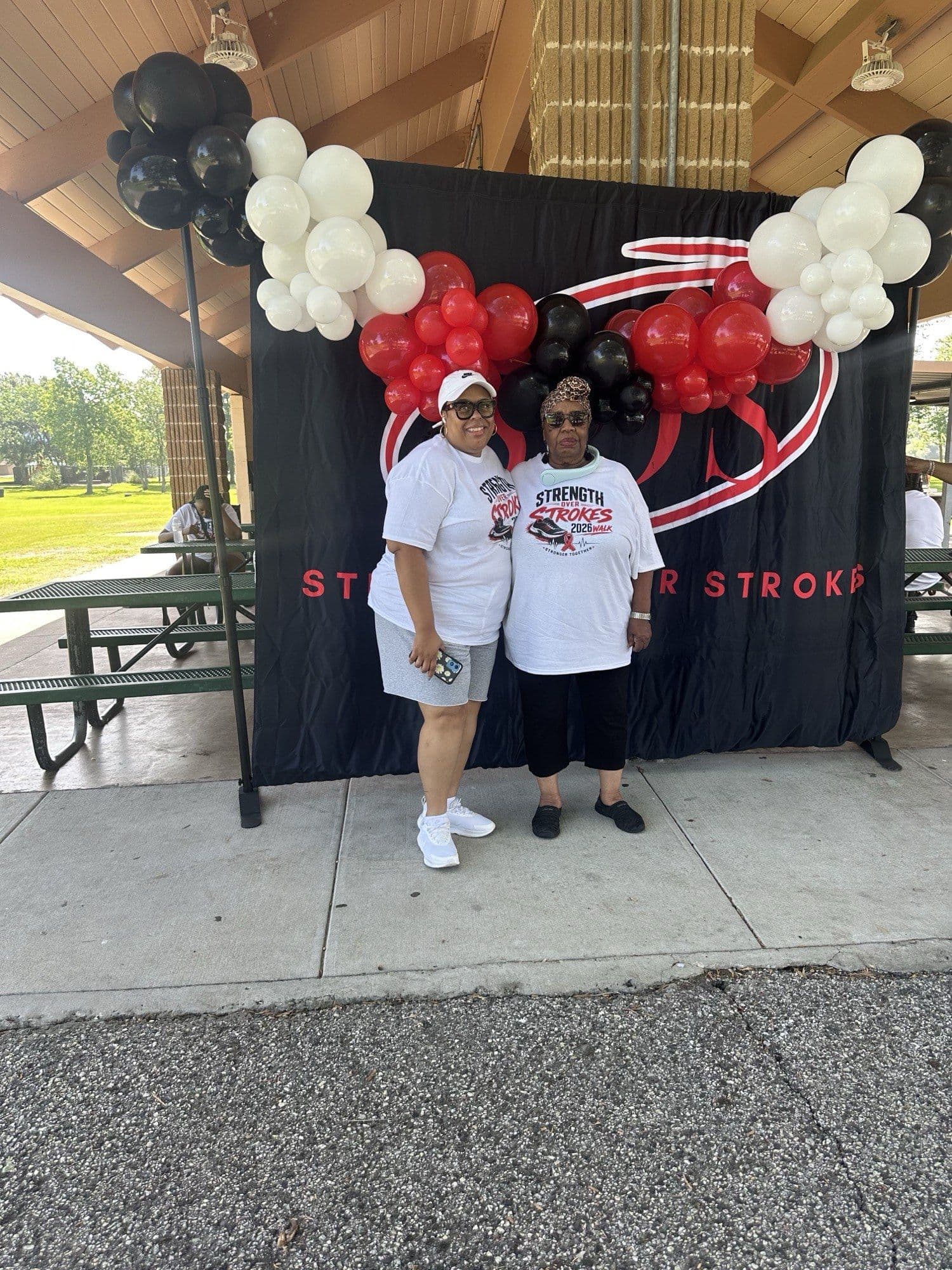 Tamika Scott in front of the Strength Over Strokes 2026 Walk backdrop and balloon arch.